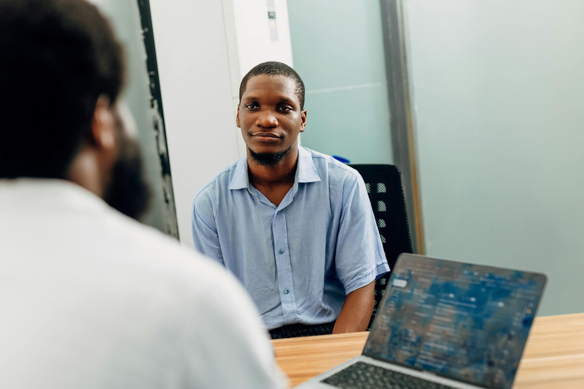 A business meeting in a modern office in Lagos, Nigeria featuring two professionals engaged in a discussion.
